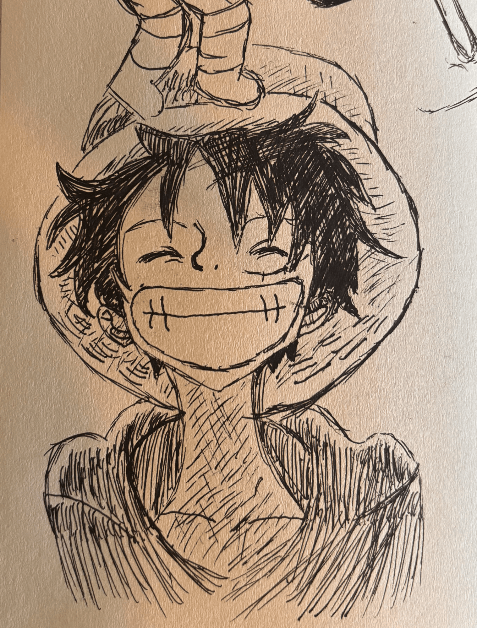 A pen sketch of Luffy from One Piece grinning with his eyes shut, his straw hat pushed back on his head